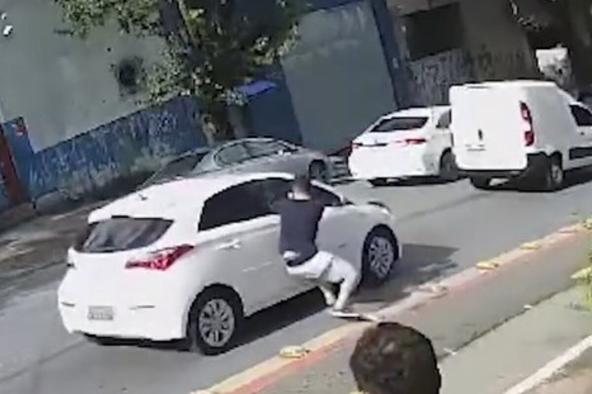 Em imagem colorida homem quebra vidro de carro branco - Metrópoles
