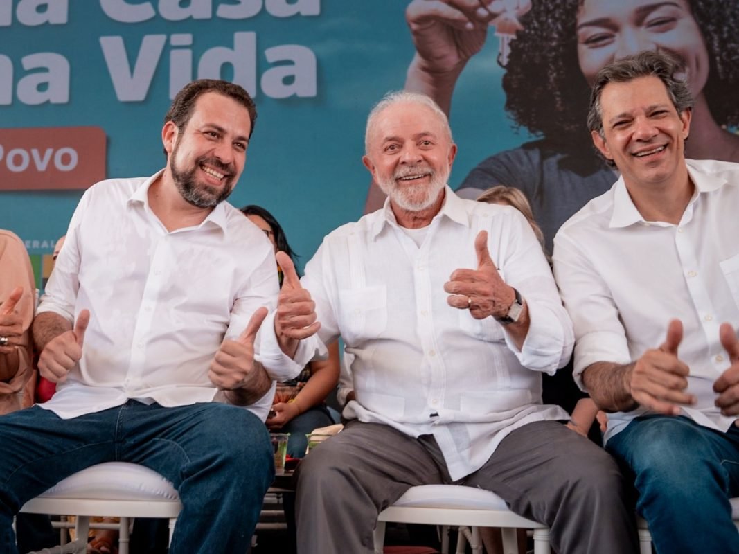 Imagem colorida mostra Boulos, Lula e Haddad sentados um ao lado do outro, sorrindo - Metrópoles
