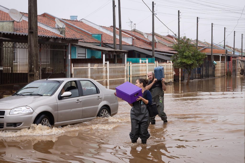 Na chuva, moradores voltam para casa no RS e lutam para salvar bens